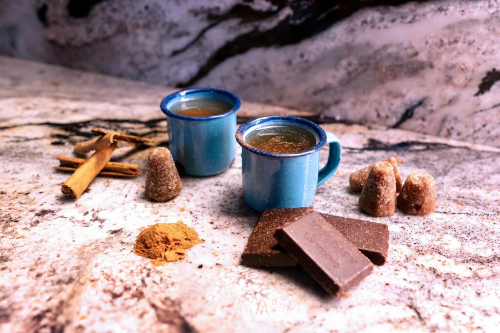Combiner boisson et chocolat avec le xocoatl et ses petites tasses avec bâtons de cannelle et cacao