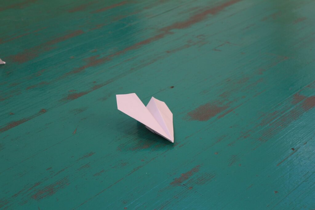Aerogami avec un avion en papier sur une table en bois