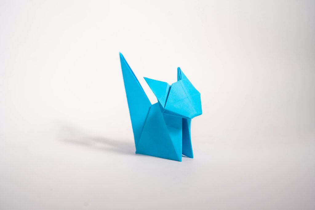 Origami minimaliste avec un chat sur réalisé en papier bleu