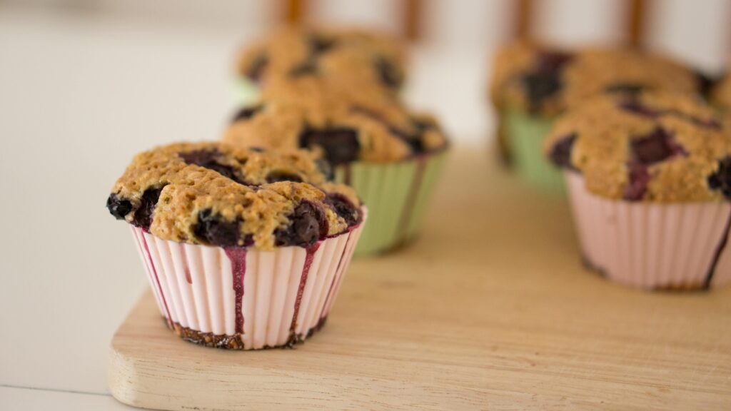 Muffin aux fruits rouges dans des emballages sur une table en bois