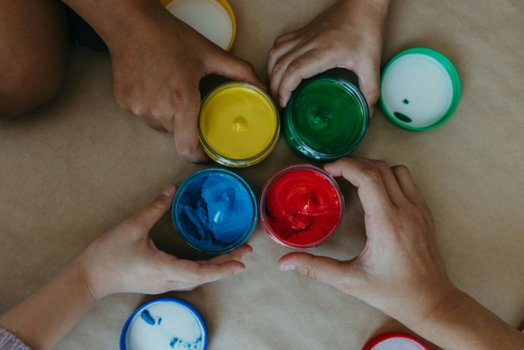 Pots de couleurs tenus par des mains