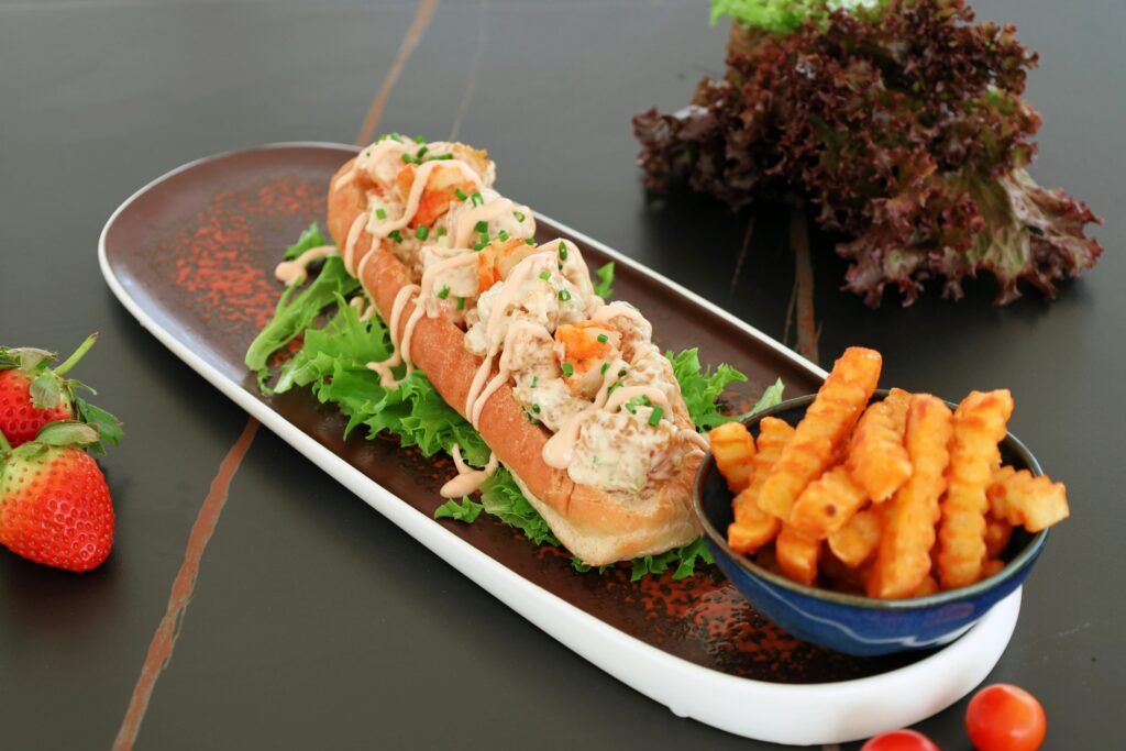Lobster roll ou guédille au homard avec des frites et des fraises
