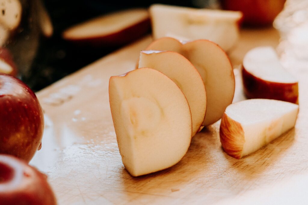 Pommes coupées en quartier sur une planche en bois